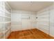 Spacious walk-in closet with multiple shelves and wooden floor at 16017 Johns Lake Rd, Clermont, FL 34711