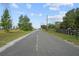 A long street view with a clear view of the road, power lines, and the homes in the background at 16017 Johns Lake Rd, Clermont, FL 34711