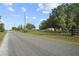 A quiet street lined with trees and well-maintained fences providing great curb appeal at 16017 Johns Lake Rd, Clermont, FL 34711