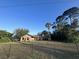 View of the house from across the yard, with a chain link fence in the foreground at 1842 Evergreen Dr, Edgewater, FL 32141