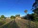 View of the house from across the yard, with a chain link fence in the foreground at 1842 Evergreen Dr, Edgewater, FL 32141