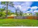 Fenced backyard with beautiful landscaping and mature trees at 221 E Fern Dr, Orange City, FL 32763
