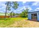 Large backyard with partial fence, shade tree, and exterior view of the home at 221 E Fern Dr, Orange City, FL 32763