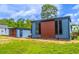 Exterior showing the side of the blue home with a brown accent section, and a detached shed at 221 E Fern Dr, Orange City, FL 32763