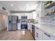 Bright modern kitchen with white cabinets, stainless steel appliances, and light wood floors at 221 E Fern Dr, Orange City, FL 32763