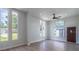 Bright living room featuring lots of natural light from large windows, a ceiling fan, and luxury vinyl flooring at 221 E Fern Dr, Orange City, FL 32763