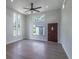 Bright living room featuring lots of natural light from large windows, a ceiling fan, and luxury vinyl flooring at 221 E Fern Dr, Orange City, FL 32763