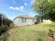 Backyard with a well-maintained lawn, lush greenery, and views of the home's exterior at 238 Miniehaha Cir, Haines City, FL 33844