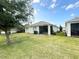 Wide backyard with well-kept grass, mature trees, and the home's exterior at 238 Miniehaha Cir, Haines City, FL 33844
