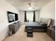 Modern bedroom with a sleek gray platform bed, entertainment center, and a ceiling fan at 238 Miniehaha Cir, Haines City, FL 33844
