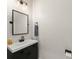 Chic powder room featuring a black vanity, square mirror, and modern lighting fixtures at 2401 Oxmoor Dr, Deland, FL 32724