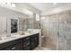 Elegant bathroom with dual sinks, a large mirror, and a walk-in shower with glass doors and a seat at 2401 Oxmoor Dr, Deland, FL 32724
