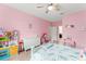 A pink bedroom featuring a bed, dresser, and play kitchen at 2401 Oxmoor Dr, Deland, FL 32724