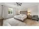 Relaxing bedroom featuring neutral tones, tray ceiling, a large window, and a comfortable bed at 2401 Oxmoor Dr, Deland, FL 32724
