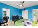 A blue bedroom featuring a dresser, desk and ensuite bathroom at 2401 Oxmoor Dr, Deland, FL 32724