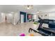 Open bonus room with tiled floors, fitness equipment, and a cozy lounge area with blue accent wall at 2401 Oxmoor Dr, Deland, FL 32724