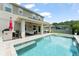 Resort-style pool with covered patio, outdoor kitchen, and lounge area for ultimate relaxation and entertainment at 2401 Oxmoor Dr, Deland, FL 32724