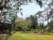 This expansive backyard is enclosed by a screened patio and lush trees at 2630 S Tanner Rd, Orlando, FL 32820