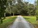 Gravel driveway surrounded by mature trees and lush landscaping at 2630 S Tanner Rd, Orlando, FL 32820
