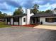 Charming single-story home featuring a white exterior, black trim, and well-manicured landscaping at 2630 S Tanner Rd, Orlando, FL 32820