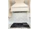 Modern gas range beneath an elegant kitchen range hood with a decorative tile backsplash at 2630 S Tanner Rd, Orlando, FL 32820