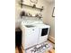 Functional laundry room with modern appliances, rustic shelves, and decorative accents at 2630 S Tanner Rd, Orlando, FL 32820