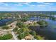 Aerial view of a lakefront home surrounded by lush greenery and a serene lake at 2916 Maldive Ct, Deltona, FL 32738