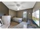 Well-lit bedroom with tile floors, ceiling fan, TV, and a window at 2916 Maldive Ct, Deltona, FL 32738