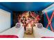 Fun bedroom featuring Avengers mural, twin beds with Captain America pillows, and vibrant blue walls at 2923 Banana Palm Dr, Kissimmee, FL 34747