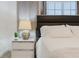 Bedside table with a lamp, a planter, and a comfortable bed in a bright room at 2923 Banana Palm Dr, Kissimmee, FL 34747