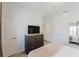 Bright bedroom with an entertainment center, two closets, a mirror, and neutral colors at 2923 Banana Palm Dr, Kissimmee, FL 34747