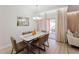 Bright dining room with seating for six, a stylish chandelier, and view to patio at 2923 Banana Palm Dr, Kissimmee, FL 34747