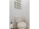 Compact powder room featuring a standard toilet, neutral wall color, and simple framed art at 2923 Banana Palm Dr, Kissimmee, FL 34747