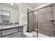 Bathroom with granite countertops, a glass-enclosed shower, and neutral tile at 3082 Mahalo Dr, Davenport, FL 33897