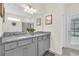 Bathroom featuring double vanity, granite countertop, gray cabinets, and decor at 3082 Mahalo Dr, Davenport, FL 33897