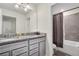 Bathroom featuring double granite sinks and a shower and tub combo at 3082 Mahalo Dr, Davenport, FL 33897