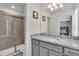 Bathroom featuring a shower, granite countertop, gray cabinets, and a single sink vanity at 3082 Mahalo Dr, Davenport, FL 33897
