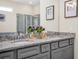 Bathroom featuring double vanity, granite countertop, gray cabinets, and walk-in shower at 3082 Mahalo Dr, Davenport, FL 33897