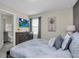 Comfortable bedroom with gray furnishings, a wall-mounted television, and view to an ensuite bathroom at 3082 Mahalo Dr, Davenport, FL 33897