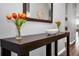Close-up view of the entryway console table with a mirror, flowers, and decorative bowl, showcasing the home's style at 3082 Mahalo Dr, Davenport, FL 33897