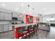 Modern kitchen with gray cabinets, granite countertops, stainless steel appliances, and an island with seating at 3082 Mahalo Dr, Davenport, FL 33897