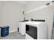 Clean laundry room featuring modern washer and dryer, with wire rack shelves for efficient storage at 3082 Mahalo Dr, Davenport, FL 33897