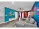 Fun-themed living room with custom cartoon artwork, large TV, and comfortable seating, perfect for entertaining at 3082 Mahalo Dr, Davenport, FL 33897