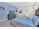 Comfortable main bedroom with blue bedding, a gray dresser, and a television screen at 3082 Mahalo Dr, Davenport, FL 33897