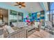 Stylish outdoor seating area featuring modern furniture, a ceiling fan, and a vibrant tropical themed mural at 3082 Mahalo Dr, Davenport, FL 33897