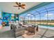 Outdoor patio area with ample seating, pool, barbecue grill, and colorful murals creates a playful entertaining space at 3082 Mahalo Dr, Davenport, FL 33897