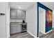 Wet bar with gray cabinets, a wine fridge, and a sink, adjacent to a graffiti-style wall art at 3082 Mahalo Dr, Davenport, FL 33897