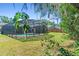 A serene screened-in pool area surrounded by lush green grass and mature trees offering a private outdoor oasis at 3150 Rider Pl, Orlando, FL 32817
