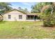 Expansive backyard featuring a well-maintained lawn, mature trees, and the back of the home with a screened in porch at 3304 Vancouver Ave, Deltona, FL 32738
