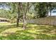 View of the backyard with mature trees, wooden fence, and ample green space for recreation at 3304 Vancouver Ave, Deltona, FL 32738